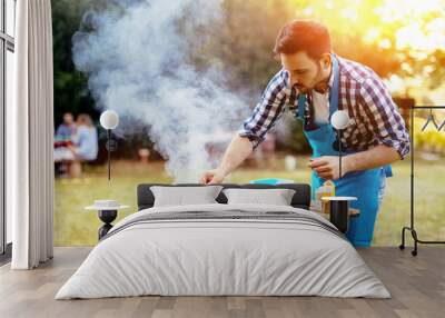 HAndsome male preparing barbecue Wall mural