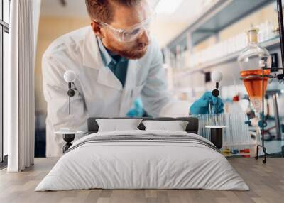 Handsome student of chemistry working in laboratory Wall mural