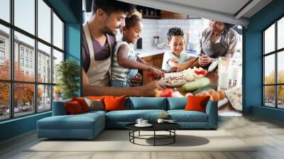 Happy african american family preparing healthy food together in kitchen Wall mural