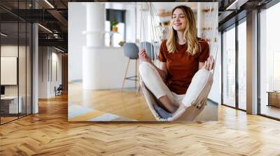 Happy and smiling young woman practicing yoga, meditate and relaxing at home Wall mural