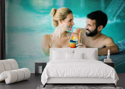 Happy attractive couple relaxing in swimming pool Wall mural