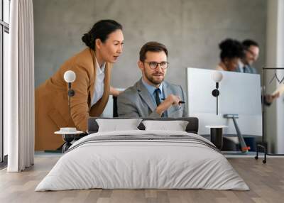 Happy businesspeople laughing while collaborating on a new project in an office. Wall mural