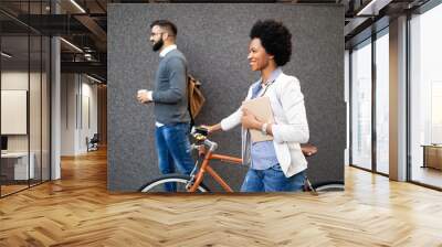 Happy cheerful businesswoman going to work by bicycle Wall mural