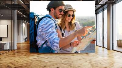 Happy couple on vacation sightseeing city with map. People travel fun honeymoon concept. Wall mural