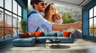 Happy couple on vacation sightseeing city with map. People travel fun love concept. Wall mural