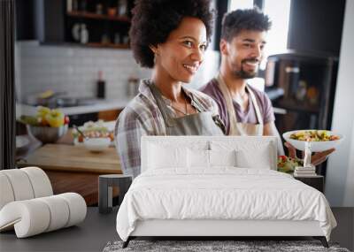 Happy couple preparing healthy food in kitchen Wall mural