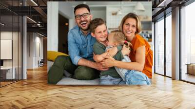 Happy family having fun time at home. Parents playing smiling with childrens together. Wall mural