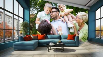 Happy family playing and enjoying picnic with children outside Wall mural