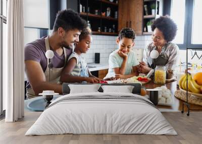 Happy family preparing healthy food in kitchen together Wall mural