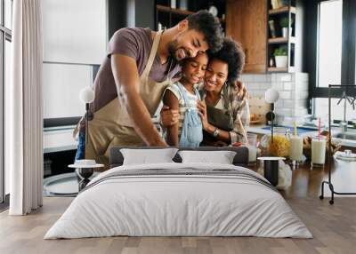 Happy family preparing healthy food in kitchen together Wall mural