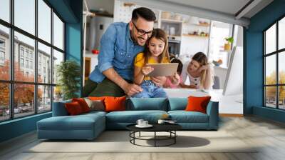 Happy family spending time at home and using digital, technology devices. Wall mural