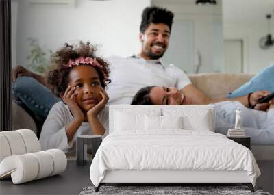 Happy family watching television at their home Wall mural