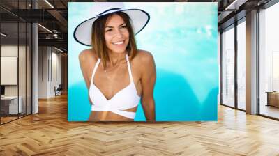 Happy fit woman in bikini and sunhat on sea beach Wall mural