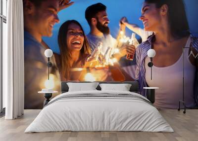 Happy friends with drinks toasting at rooftop party at night Wall mural