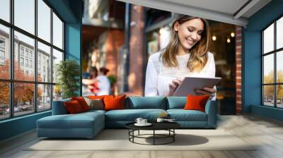 Happy girl working online or studying and learning while using tablet Wall mural