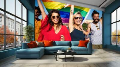 Happy group of people hanging out in the city waving LGBT with pride flag Wall mural