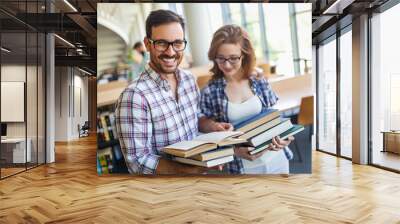 Happy group of students studying and working together in a college library Wall mural