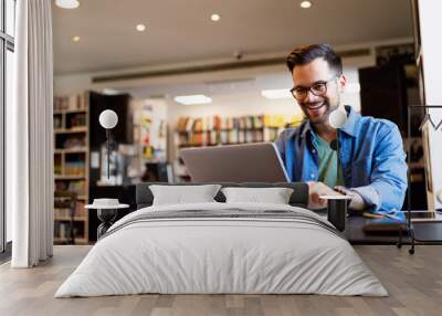 Happy man working on laptop. Technology people work study concept Wall mural