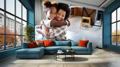 Happy mother playing, having fun, hugging with her daughter at home Wall mural