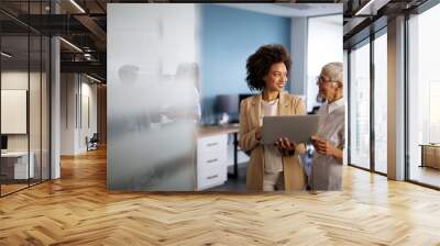 Happy multiethnic smiling business women working together in office Wall mural