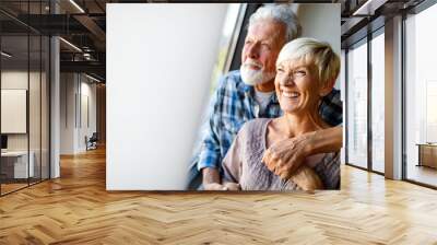 Happy senior couple in love hugging and bonding with true emotions at home Wall mural