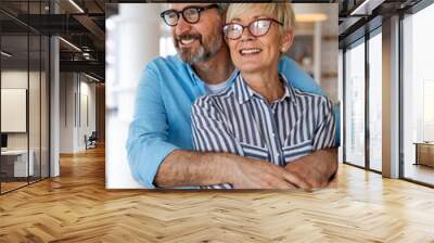 Happy senior couple in love hugging and bonding with true emotions at home Wall mural