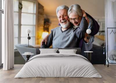 Happy senior couple using notebook at home and having fun together. Technology people concept Wall mural