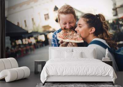 Happy students eating pizza on street Wall mural