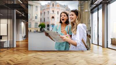 Happy travel together of two beautiful women in city centre. Wall mural