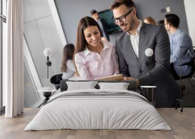 Happy young business colleagues in modern office Wall mural