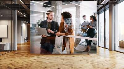 Happy young business people colleagues talking working in office Wall mural