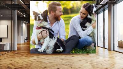 Happy young couple walking, playing with dogs in a park Wall mural