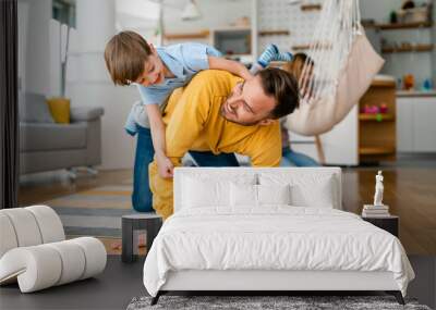 Happy young family having fun and being playful at home Wall mural