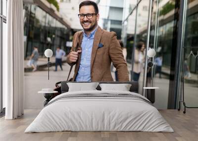 Happy young stylish businessman going to work by bike Wall mural