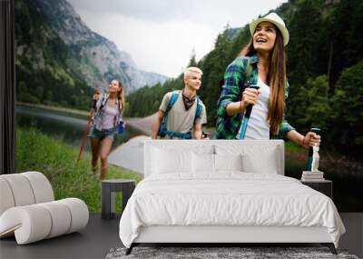 Hiking with friends is so fun. Group of young people with backpacks together Wall mural