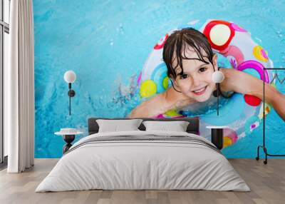 Little girl in swimming pool with float ring Wall mural