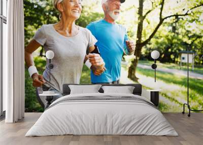 Mature couple jogging and running outdoors in city Wall mural