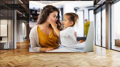 Mother at home trying to work with child distracting her Wall mural