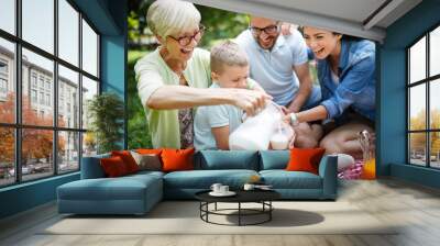 Multi generation family enjoying picnic in a park Wall mural