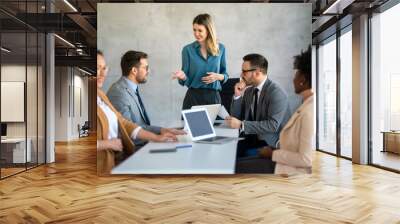 Multicultural professional businesspeople working together on research plan in boardroom. Wall mural