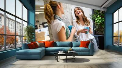 office coffee break with two business female colleagues having fun chatting over cups of coffee Wall mural