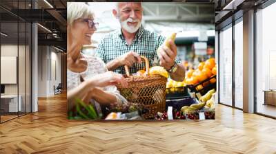 Only the best fruits and vegetables. Beautiful mature couple buying fresh food on market Wall mural