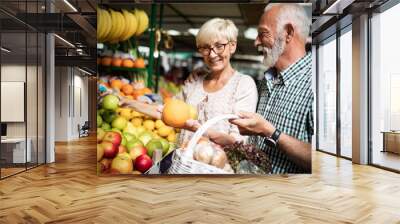 Only the best fruits and vegetables. Beautiful senior couple buying fresh food on market Wall mural