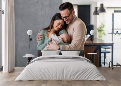 Peaceful young married couple enjoying being family, parents, holding new born baby in arms Wall mural