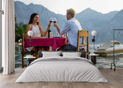 People, vacation, love and romance concept. Young couple enjoying a romantic dinner on beach. Wall mural