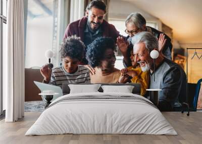 Portrait of a happy multigeneration family using electronic devices at home together Wall mural