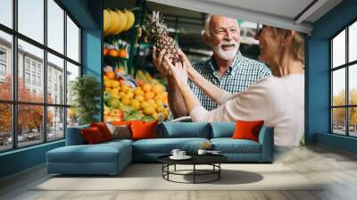 Portrait of beautiful elderly couple in market buing food Wall mural