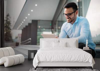 Portrait of businessman in glasses holding tablet Wall mural