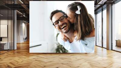 Portrait of father and daughter playing at home Wall mural