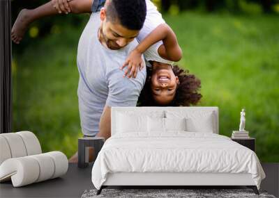 Portrait of happy black father carrying daughter on back outdoors. Family happiness love concept. Wall mural